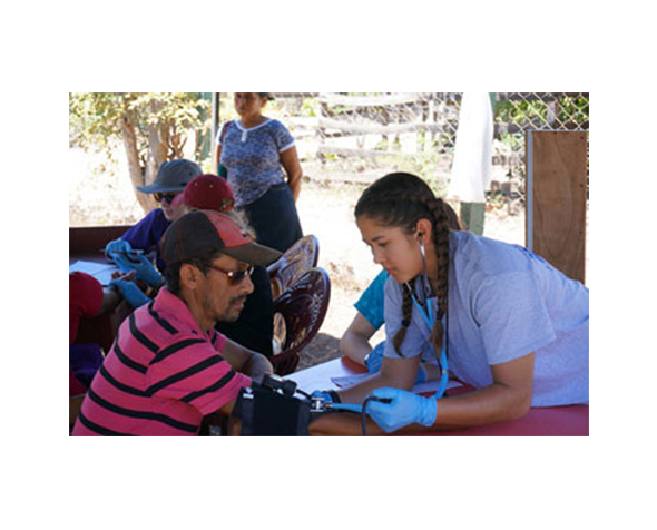 International business major 和 women’s volleyball player Cassidy Rooke takes a patient’s blood pressure at the medical clinic the DU group set up La Laguna. 照片:JD Arora